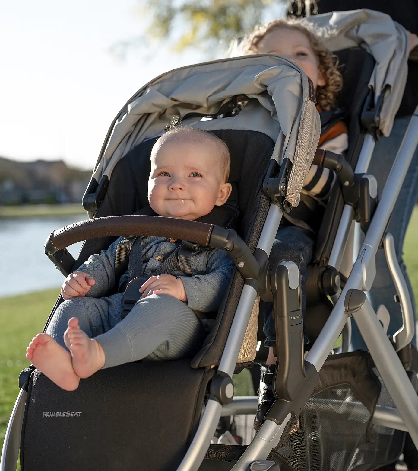 Due bambini a bordo di un passeggino Vista V3 con seggiolino per bambini e RumbleSeat V3 installato