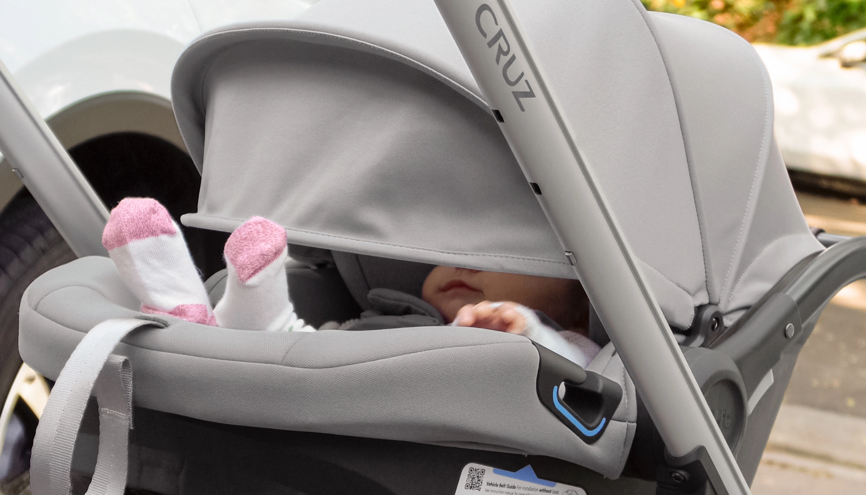 Child comfortably secured in car seat with shade extended