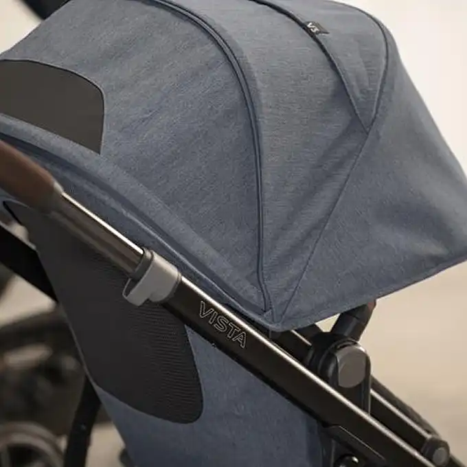 Side view of a UPPAbaby Vista stroller in blue fabric, highlighting the canopy and frame with "Vista" branding on the side.